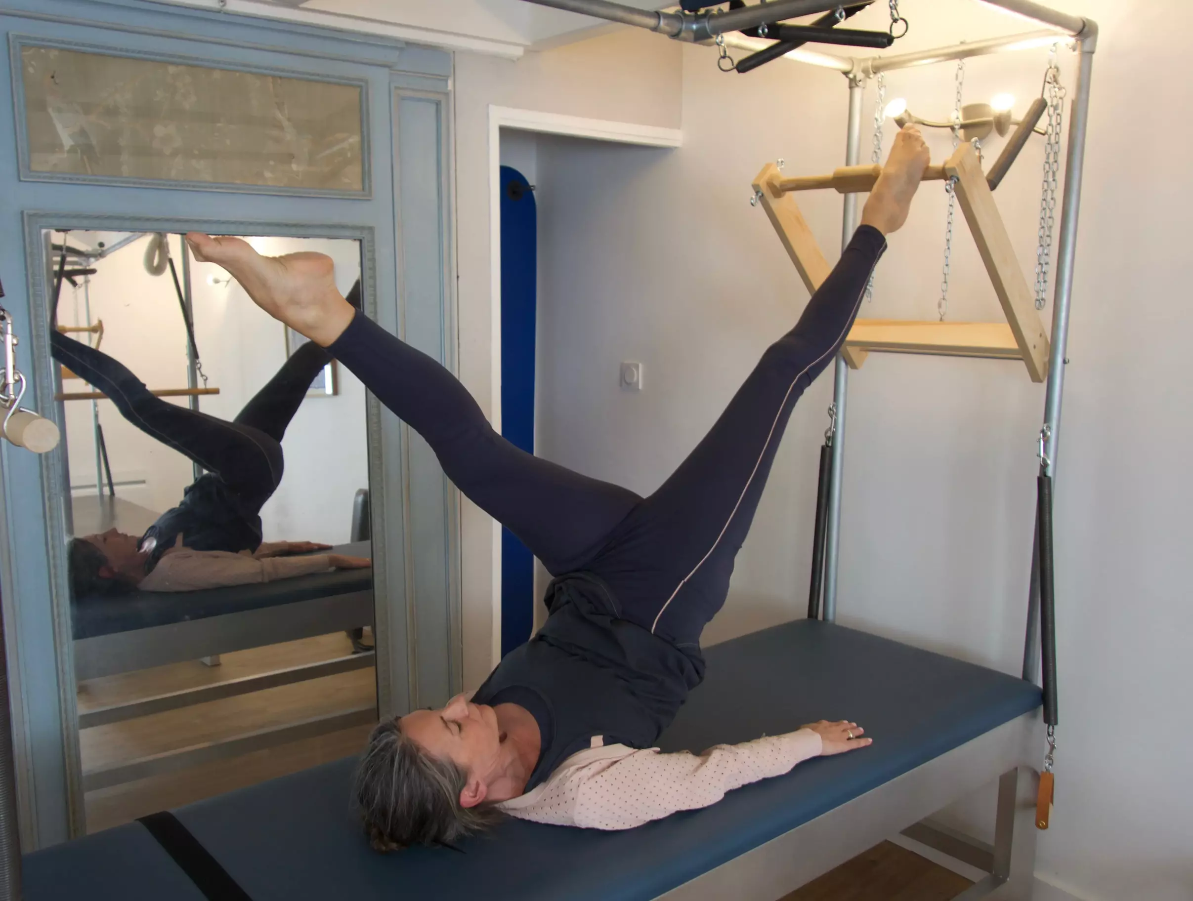 Femme faisant un exercice de Pilates sur un Cadillac.